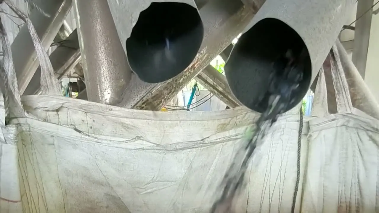 Sorted plastic flakes running from two pipes into a bulk bag