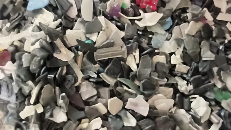 Crushed plastic flakes in the feed chute, close up