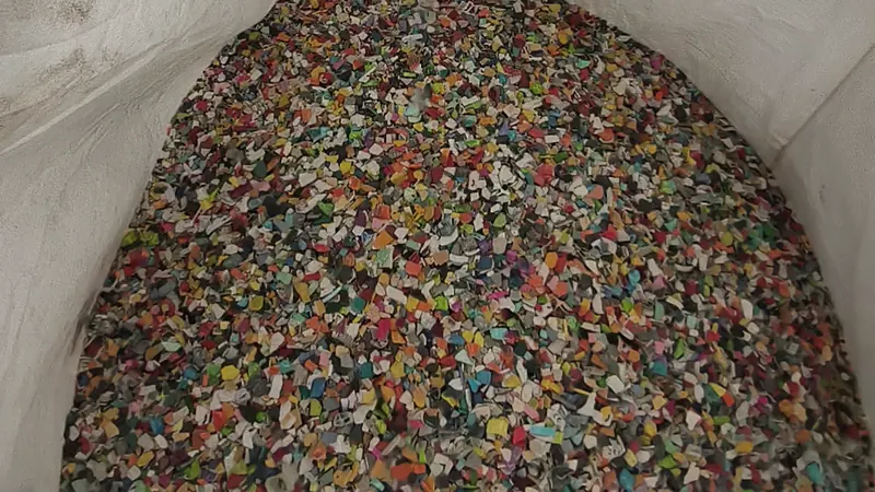 A mound of sorted, colourful plastic flakes in a bulk bag