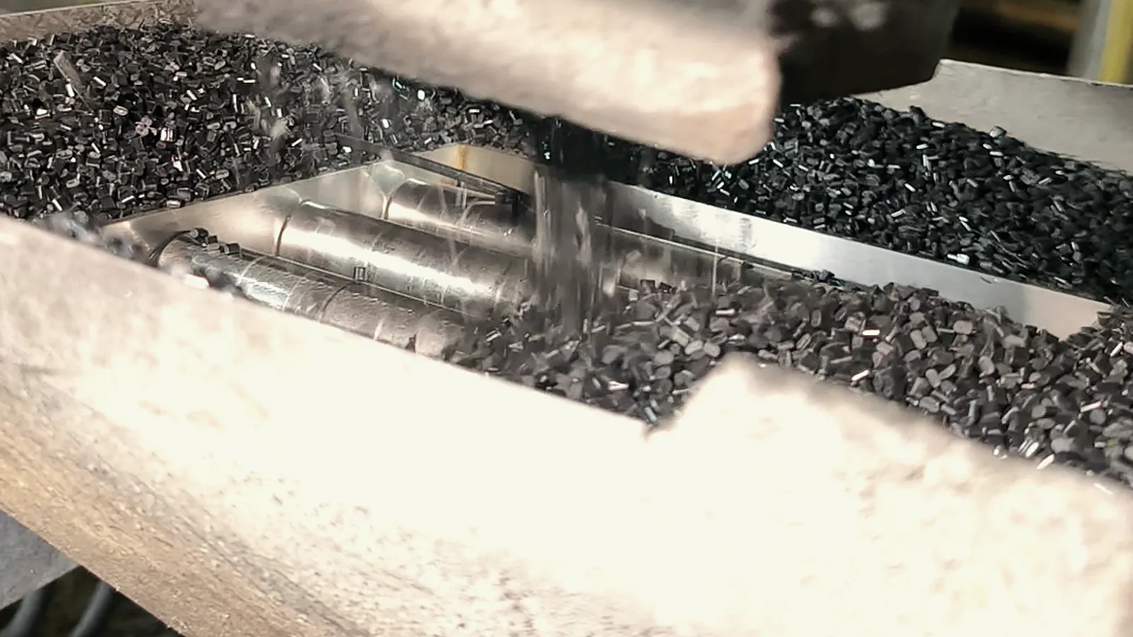 Fresh plastic pellets falling from the cutter onto the line