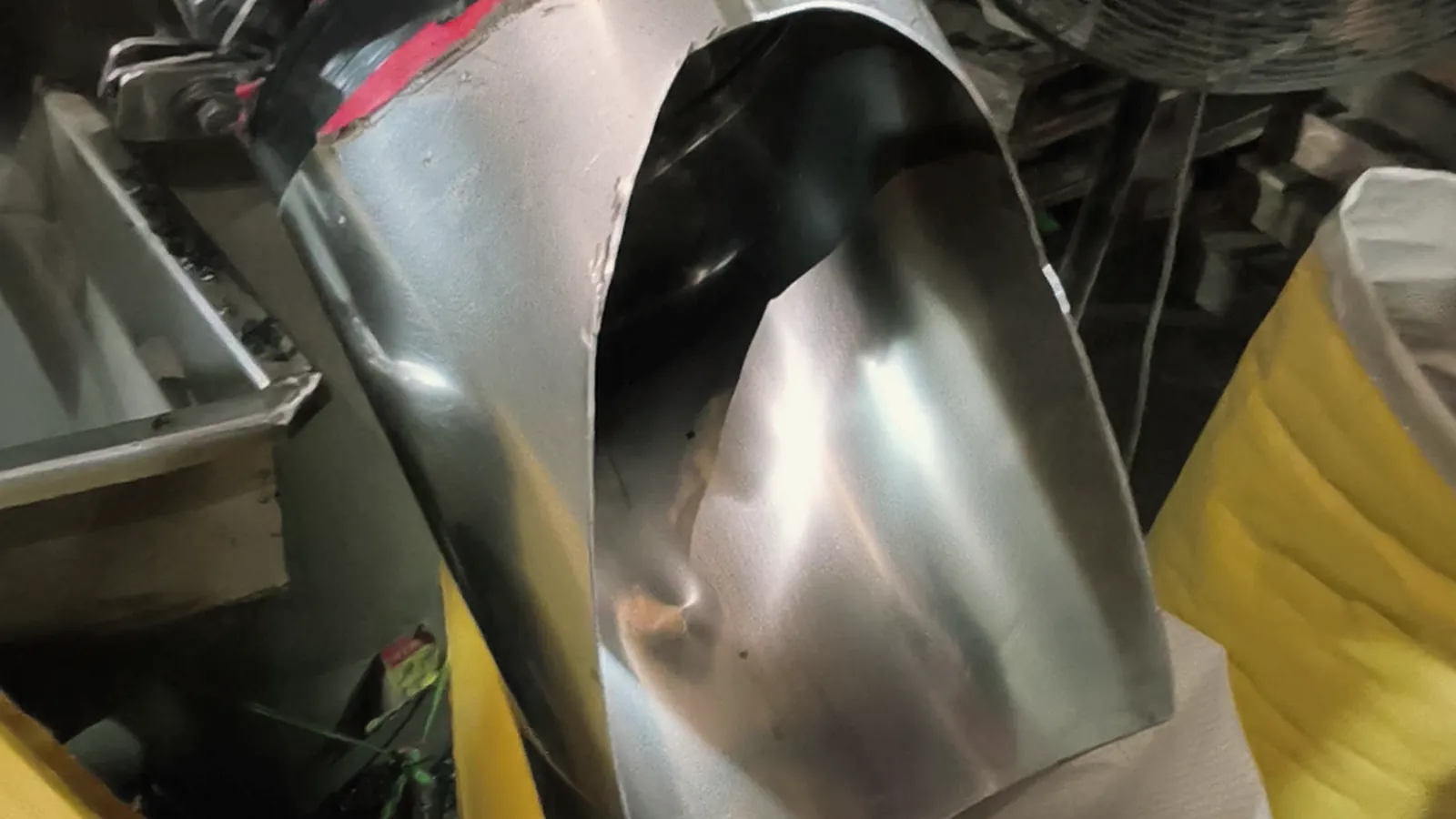 Resin pellets running from a steel spout into a 25 kg bag
