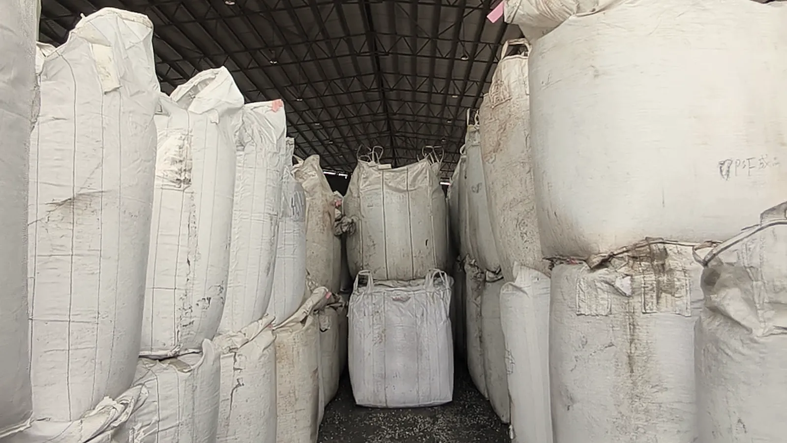 An aisle of filled bulk bags in the warehouse