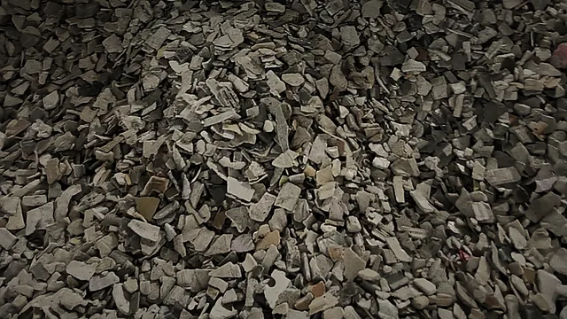 A bulk bag filled with sorted grey plastic flakes