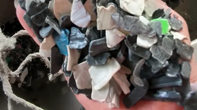A handful of clean crushed plastic flakes in mixed colours, close up