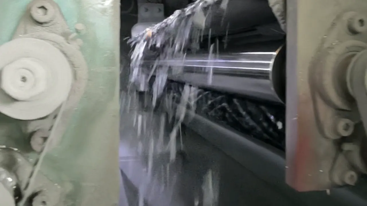 Plastic flakes flying off the rollers inside a sorting machine